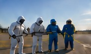 Brigada con trajes de protección aplicando cortina de agua